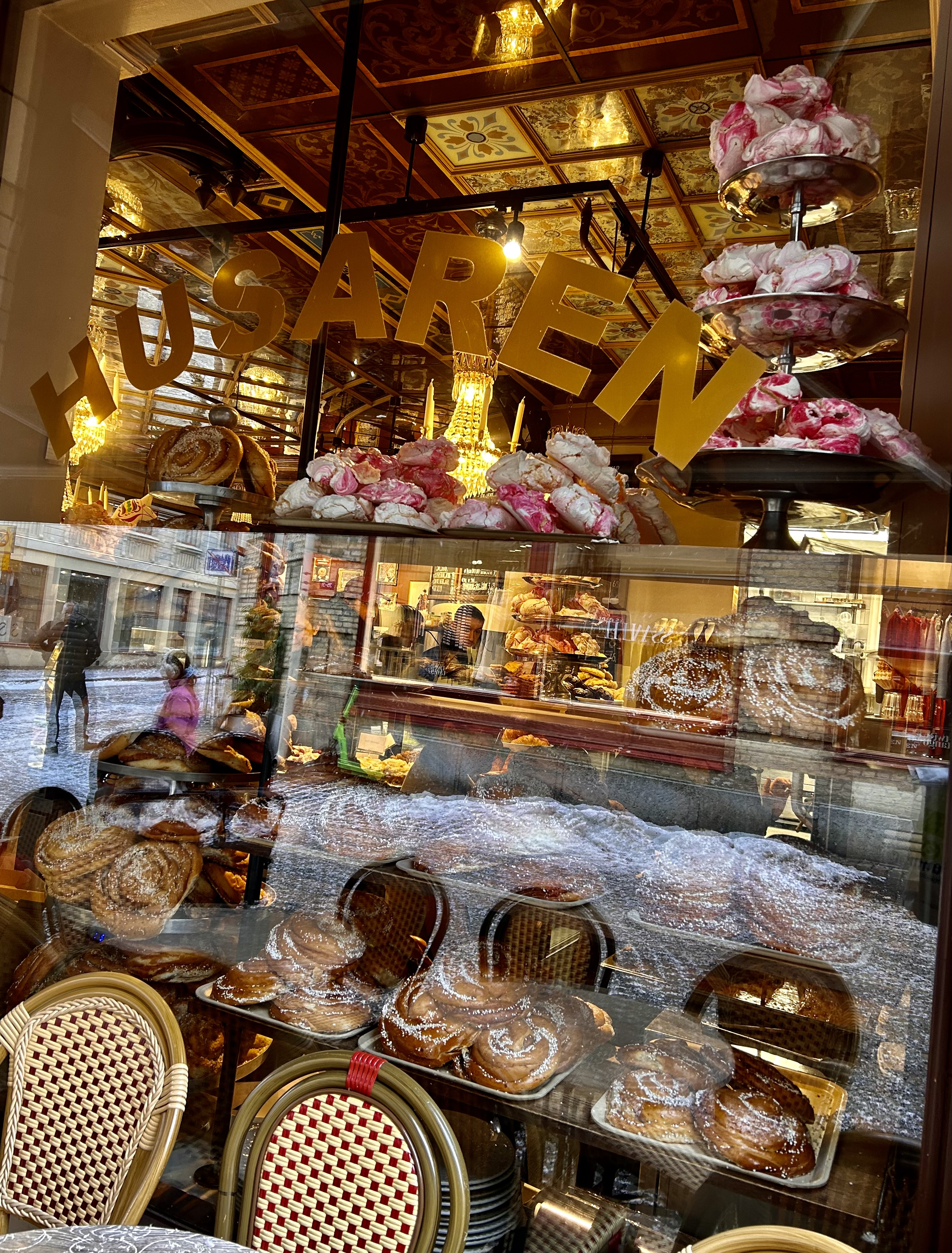 Café window with pastries and outdoor seating in the Haga district