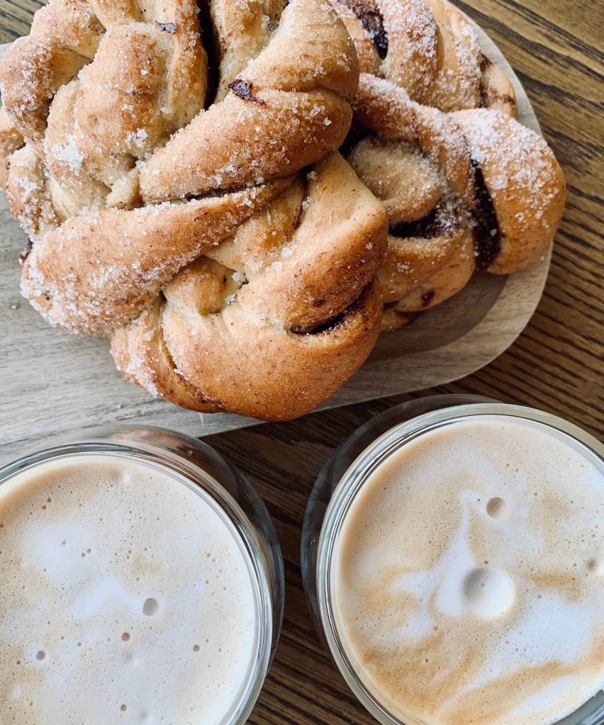 Cinnamon bun and cups of coffee during a fika break