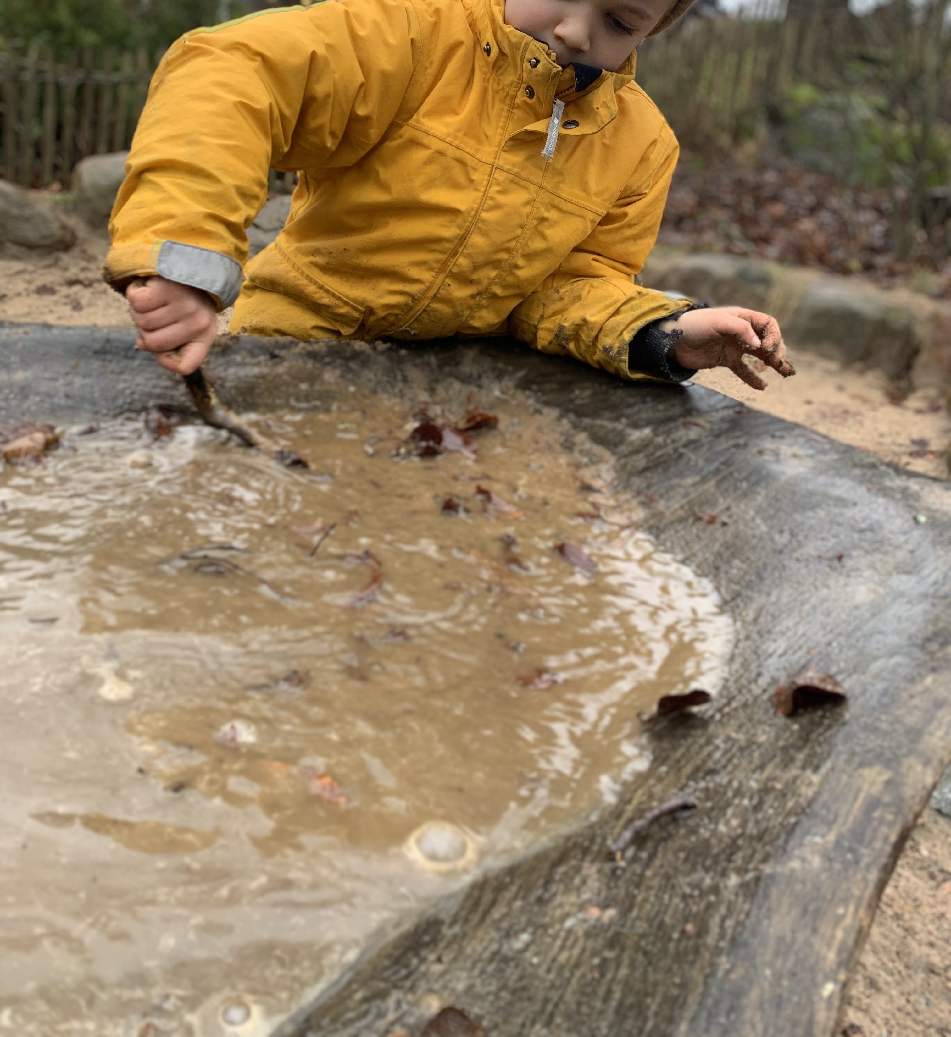 Child playing with water at a nature playground in Slottsskogen
