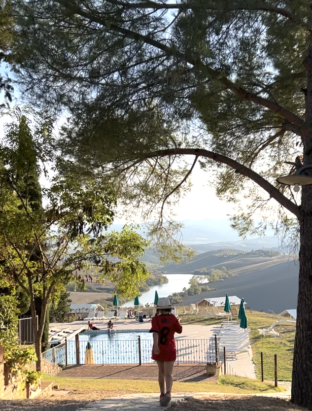 Countryside agriturismo in Italy with a pool overlooking rolling hills and a lake.
